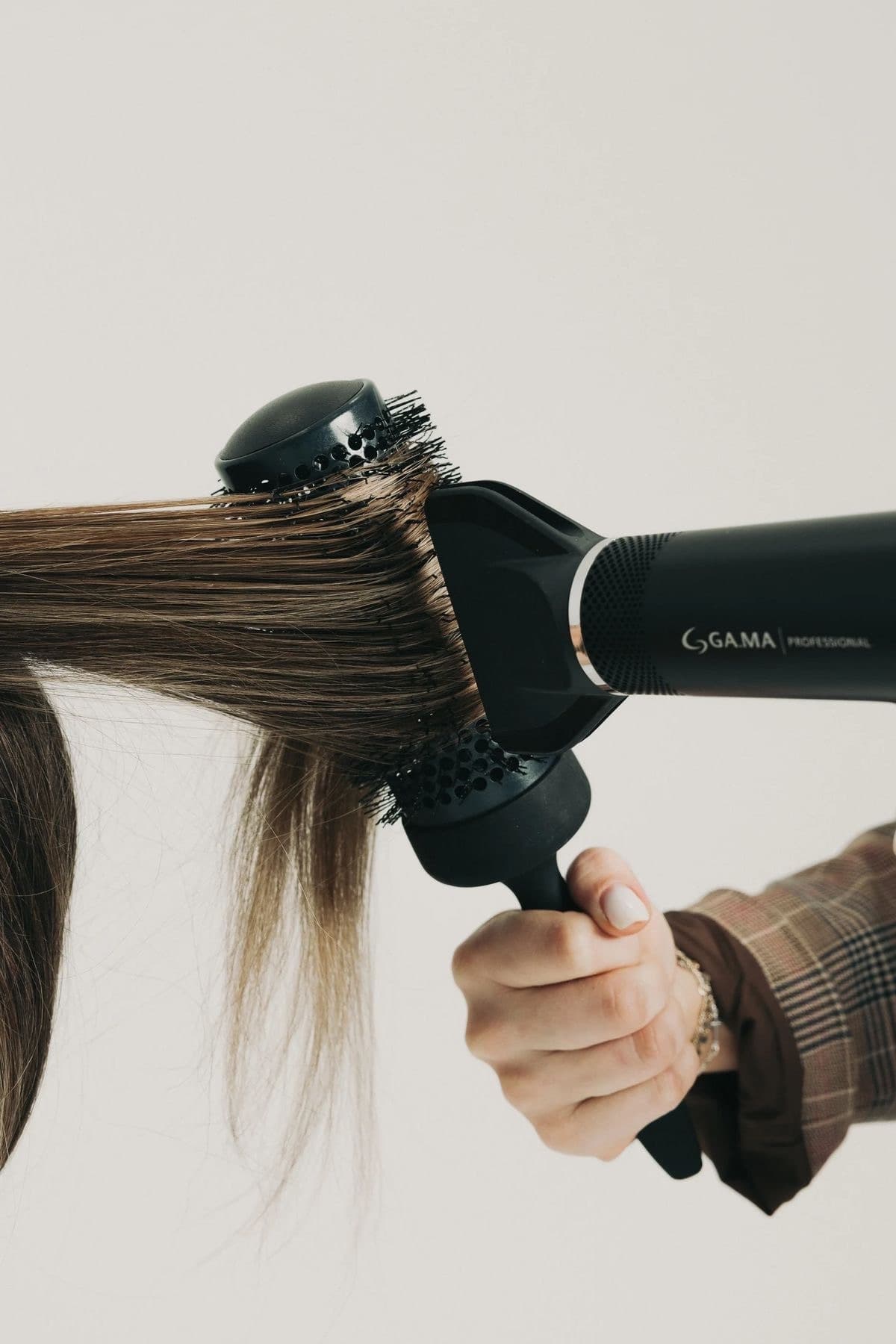 Hair being blow dried around a round brush