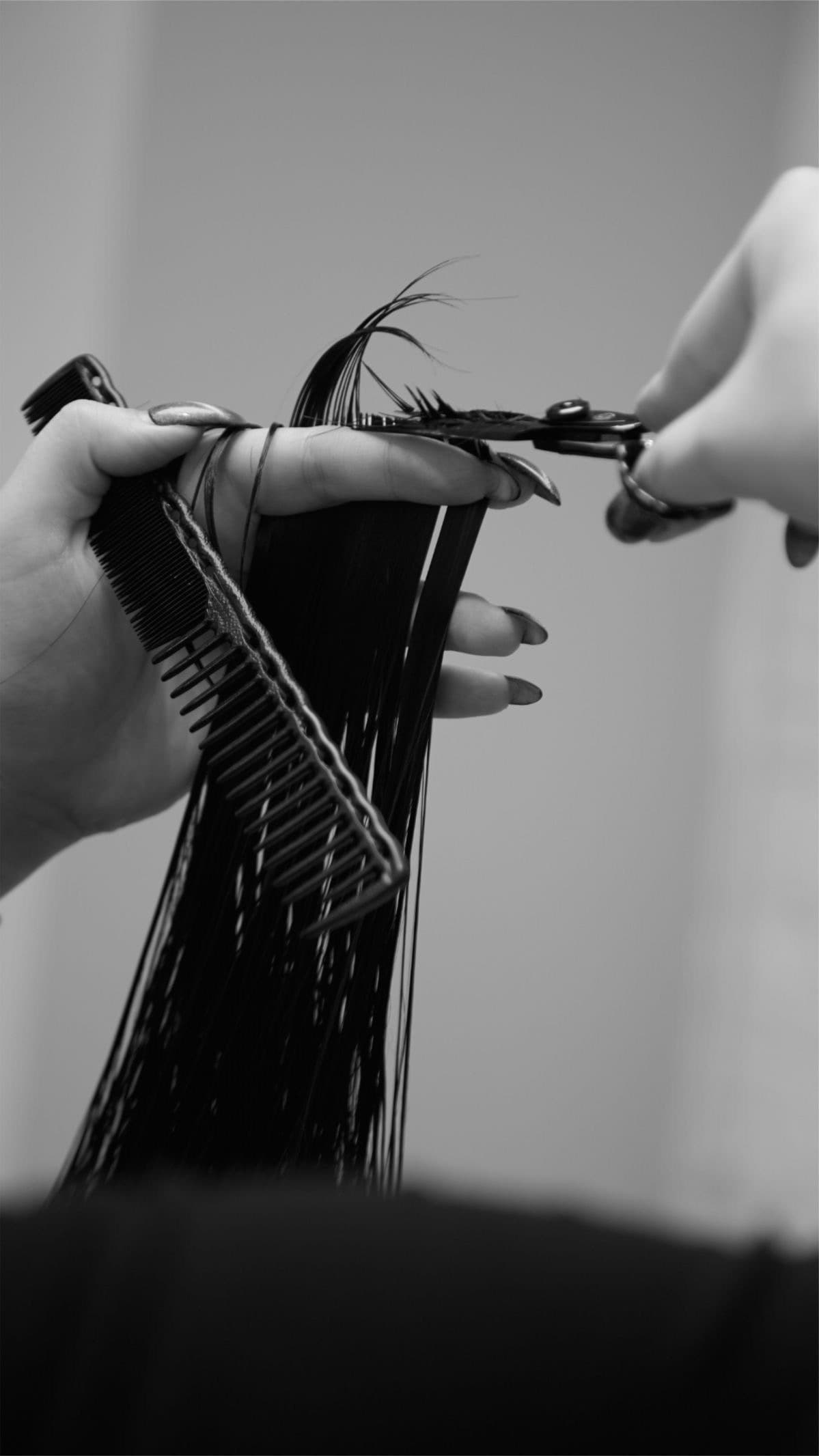 Hair being cut with scissors and a comb