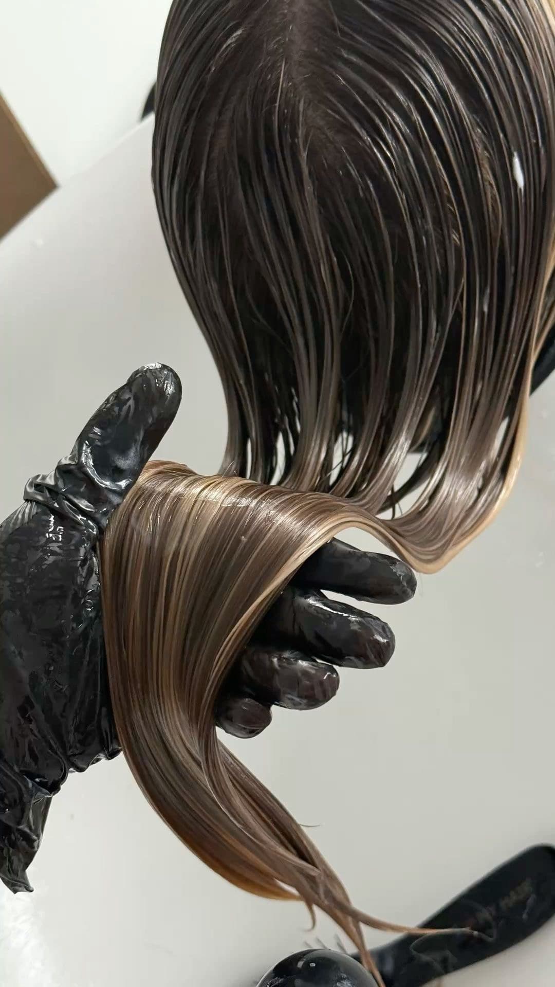 Wet hair held in a gloved hand